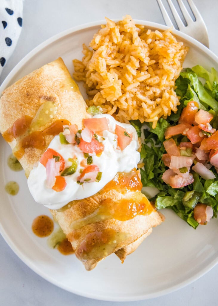 looking down on a plate with chimichanga, lettuce and rice