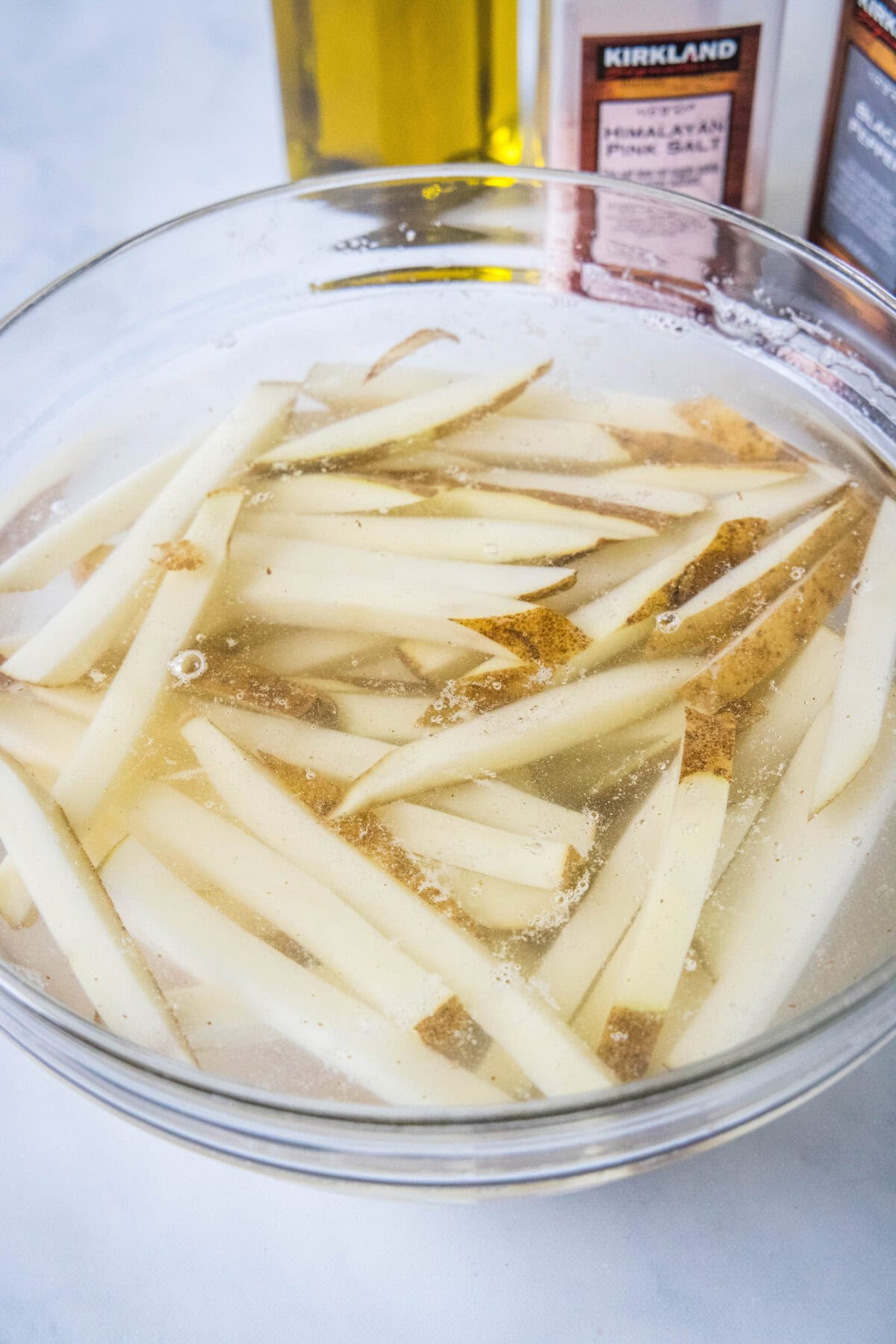 Cut French fries soaking in a bowl of water.