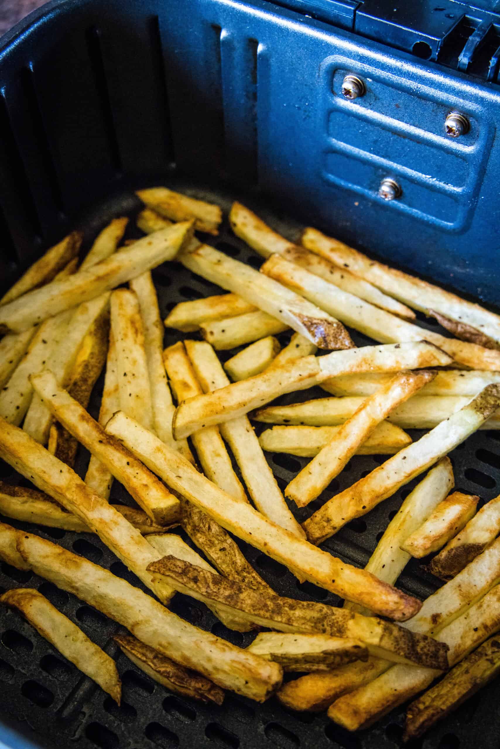 Crispy homemade French fries inside the air fryer basket.