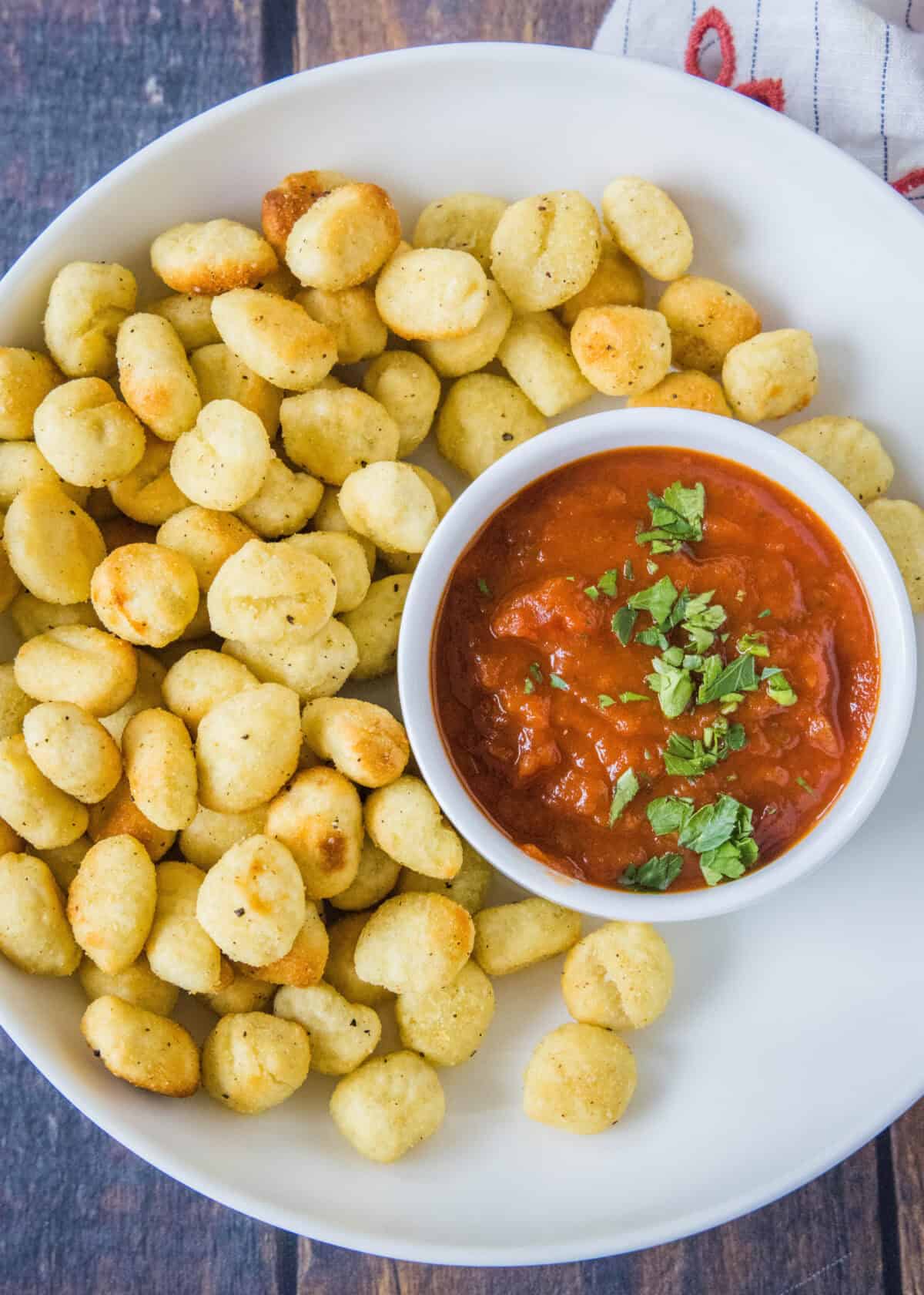 crispy gnocchi on a plate with bowl of marinara sauce