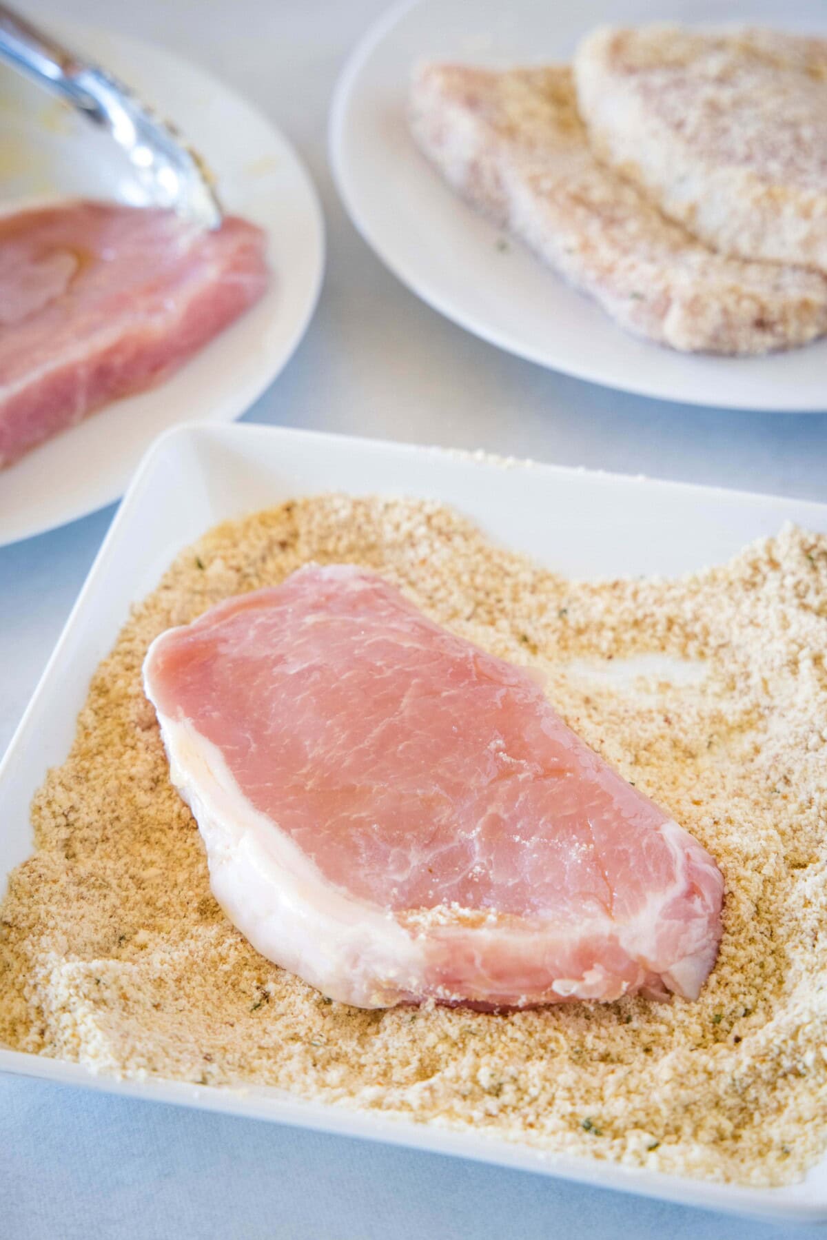 putting pork in parmesan cheese mixture