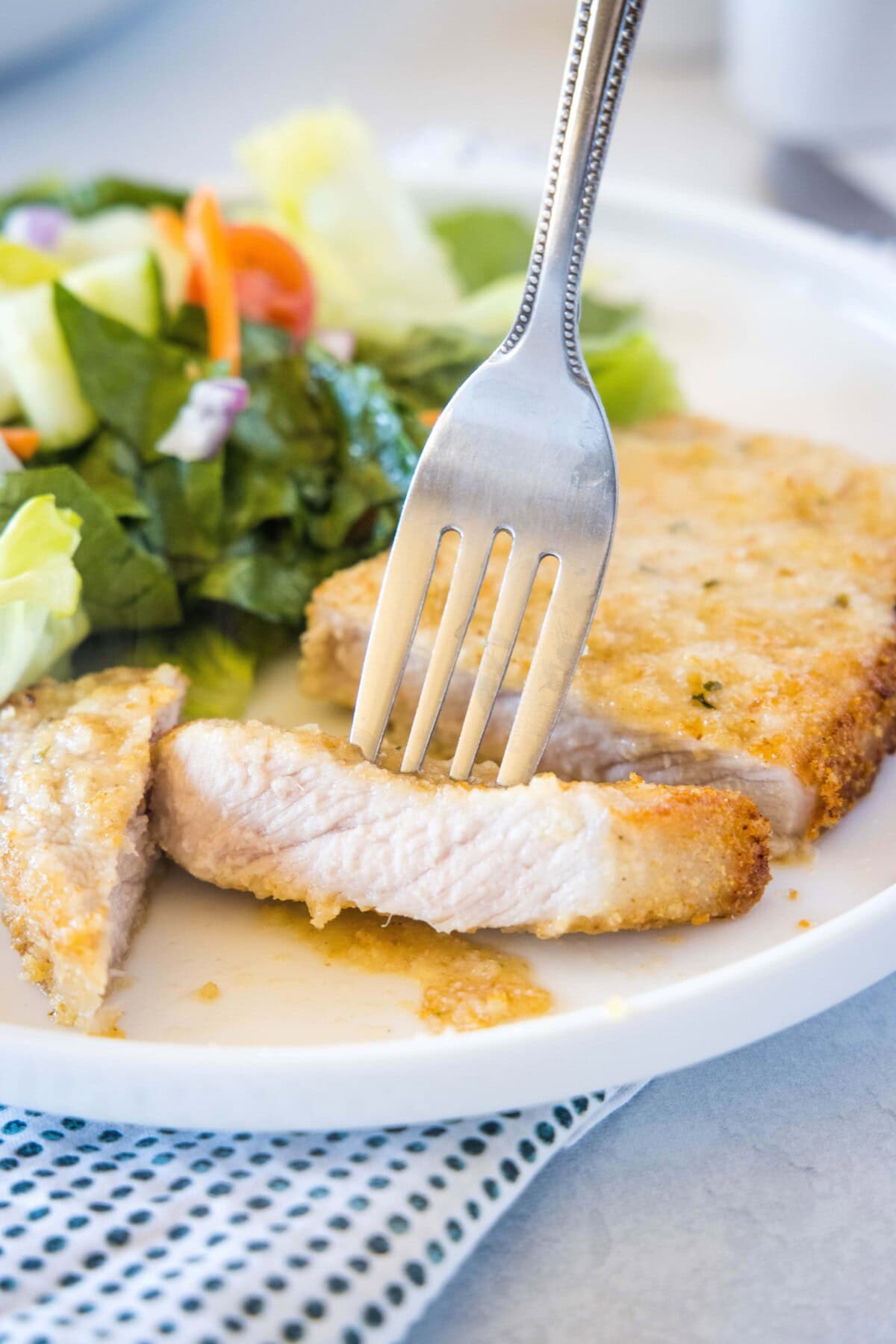sliced pork chop on a plate with a fork