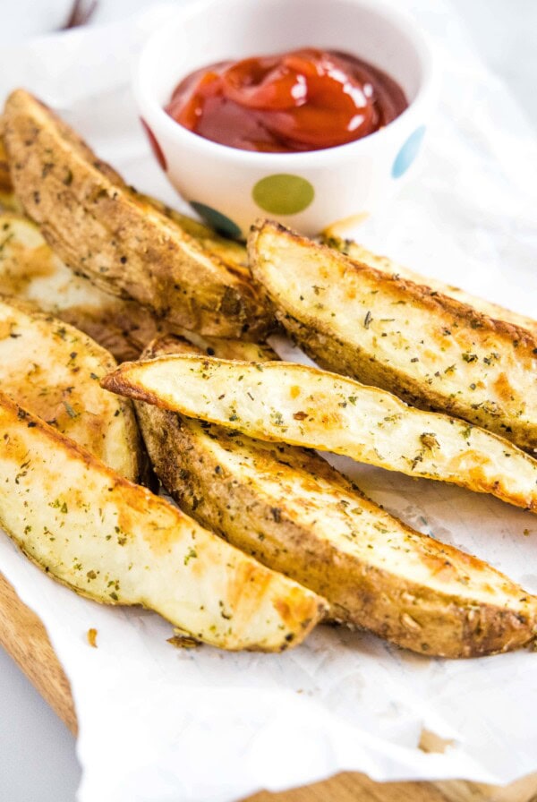 cropped picture of potato wedges with bowl of ketchup