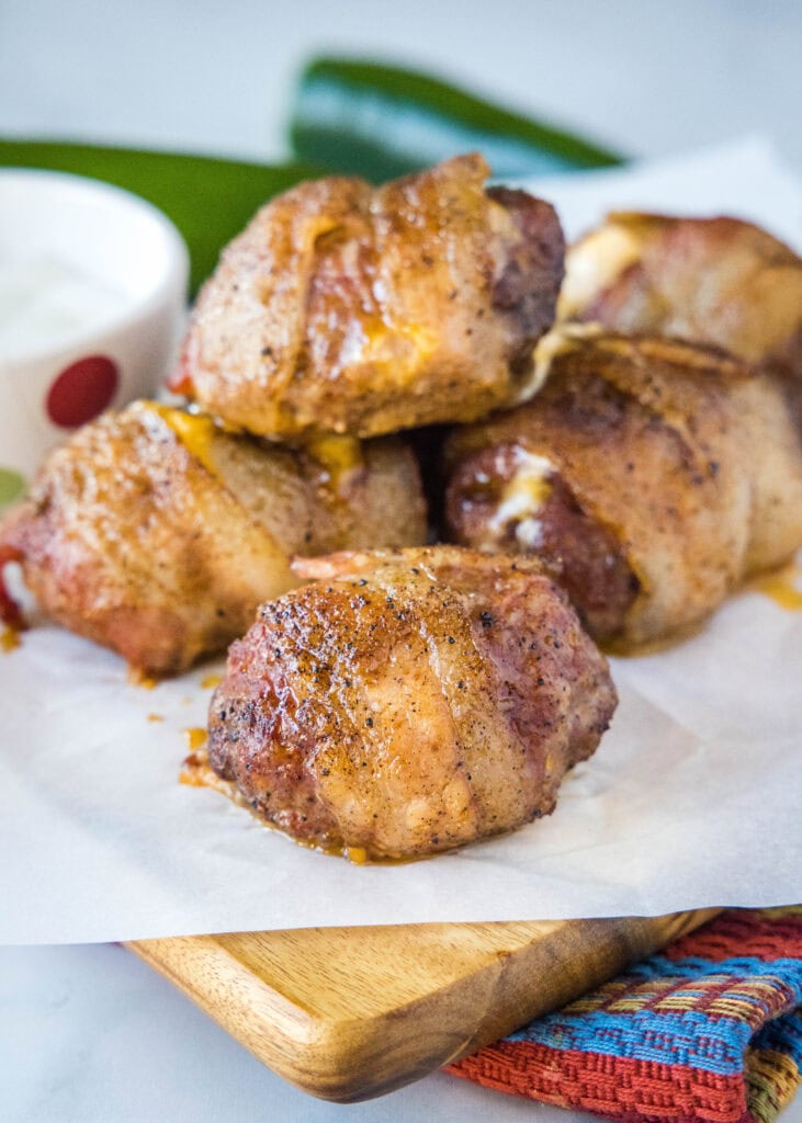 bacon wrapped armadillo eggs on a cutting board