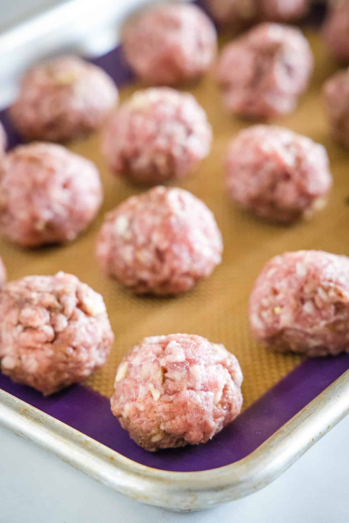 asian meatballs on a baking sheet ready for the oven