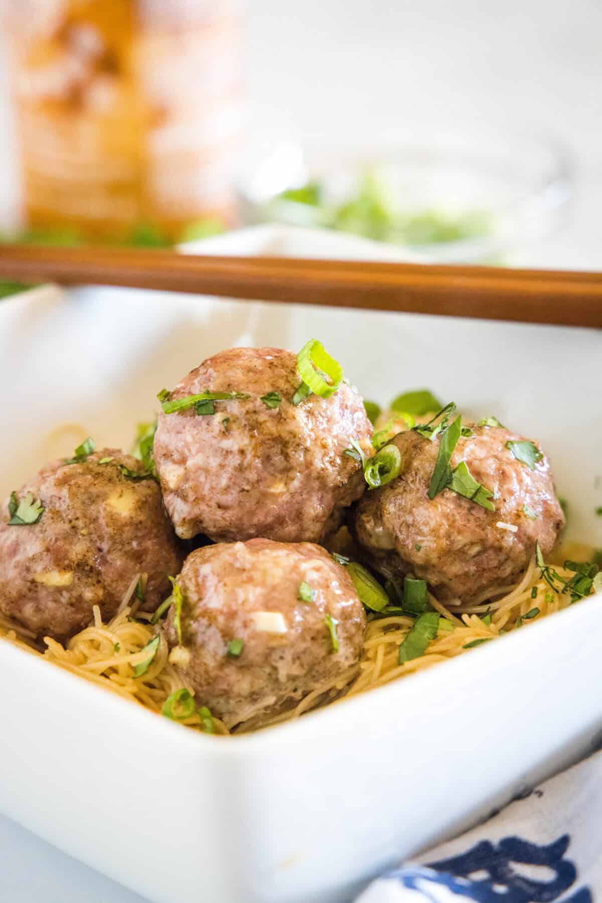 asian meatballs over rice noodles in a bowl
