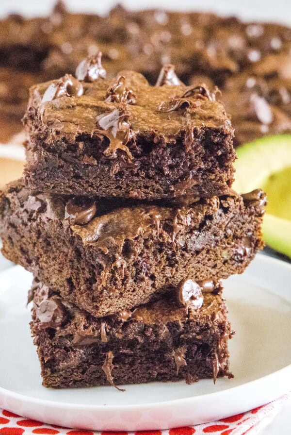 close up avocado brownies stacked on a white plate