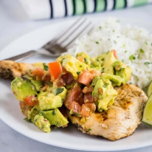 close up avocado chicken on a white plate