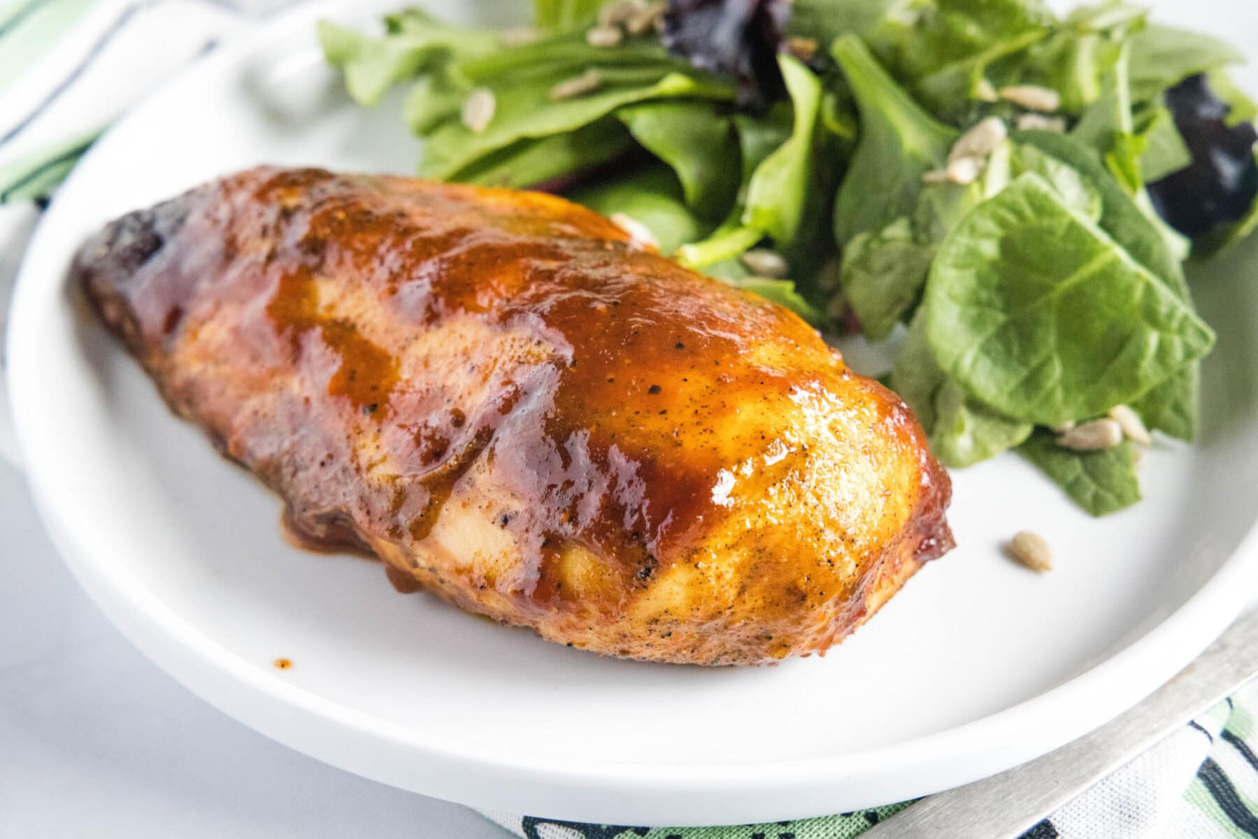 Overhead view of a plate with a salad and a BBQ chicken breast