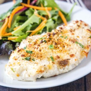 close up baked caesar chicken on a white plate