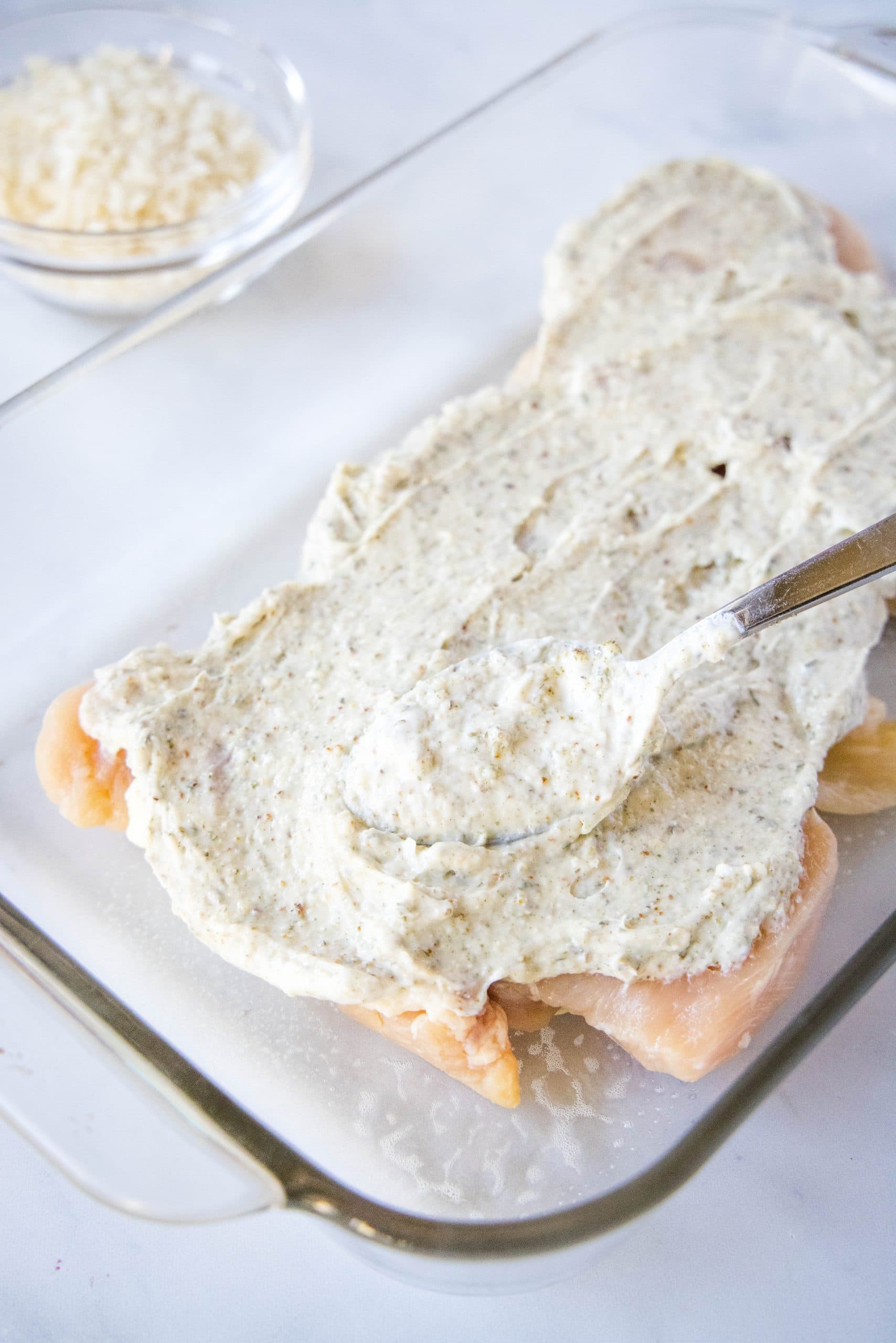 spreading ranch on chicken breasts