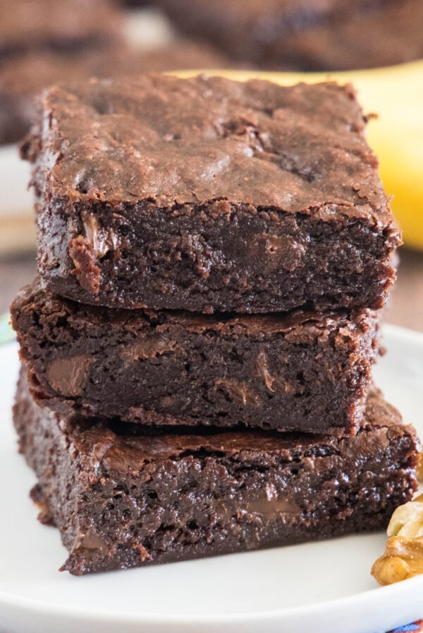 cropped close up banana brownies stacked on a white plate