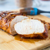 A piece of turkey sitting on top of a wooden cutting board