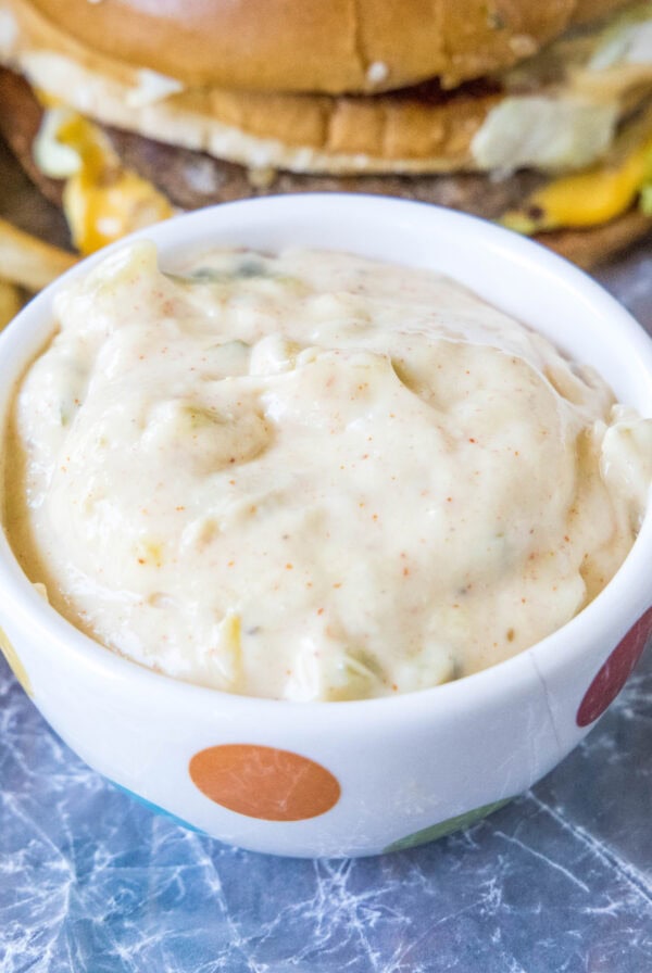 Big Mac Sauce in a small serving bowl, with a burger and fries in the background.