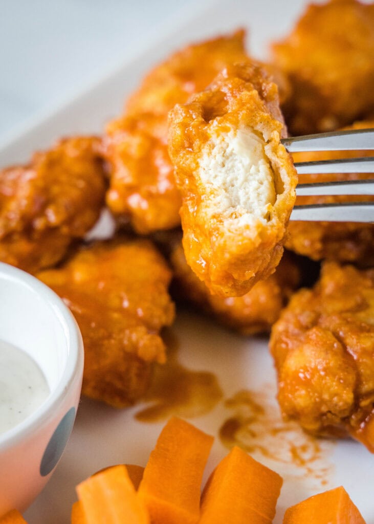 a piece of chicken on a fork with a bite out of it