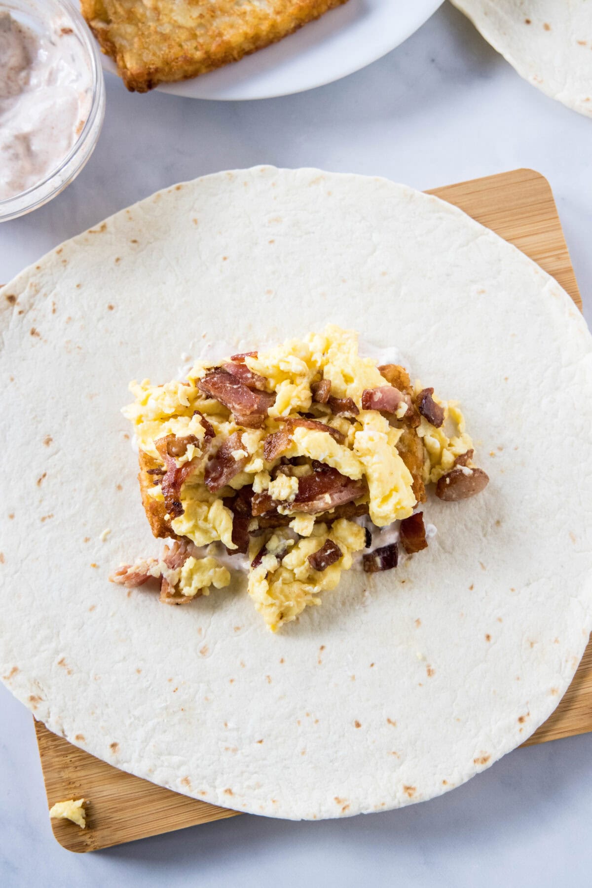 Crunchwrap filling ingredients layered in the center of a large flour tortilla.