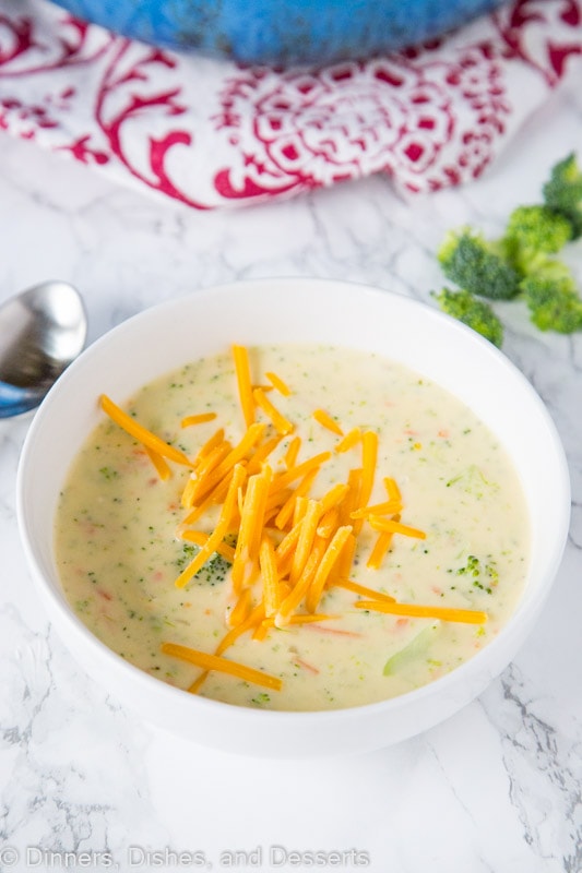 A bowl of broccoli cheese soup with cheese on top