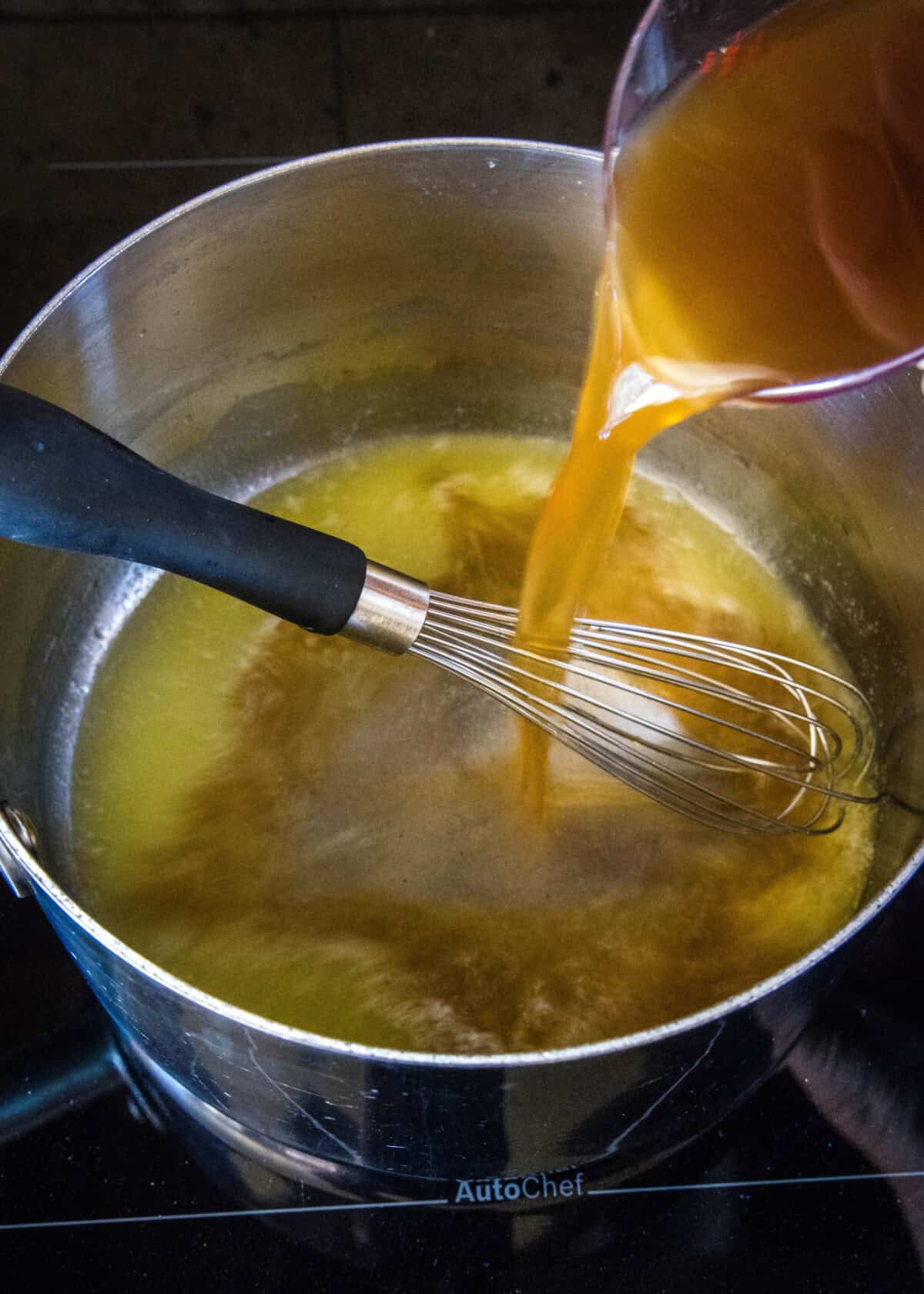 pouring broth into a sauce pan