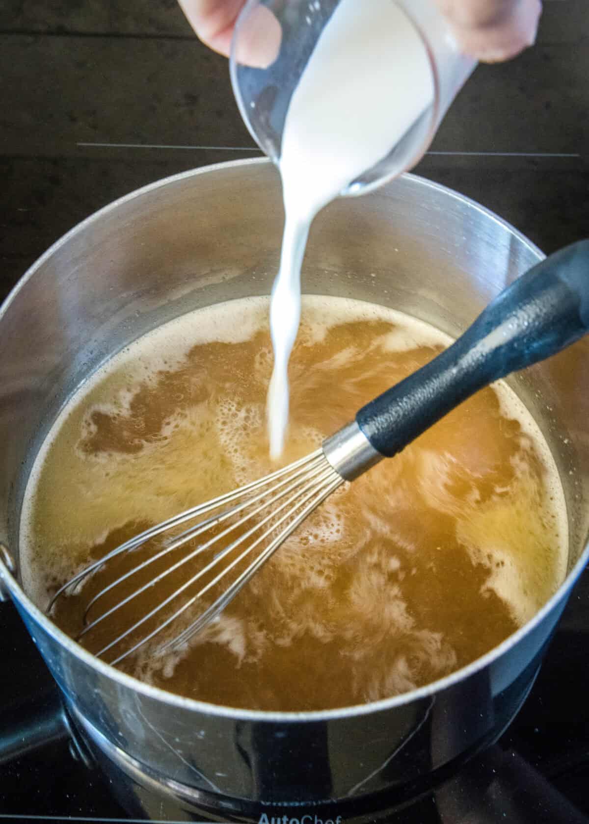 pouring slurry into broth mixture in a saucepan