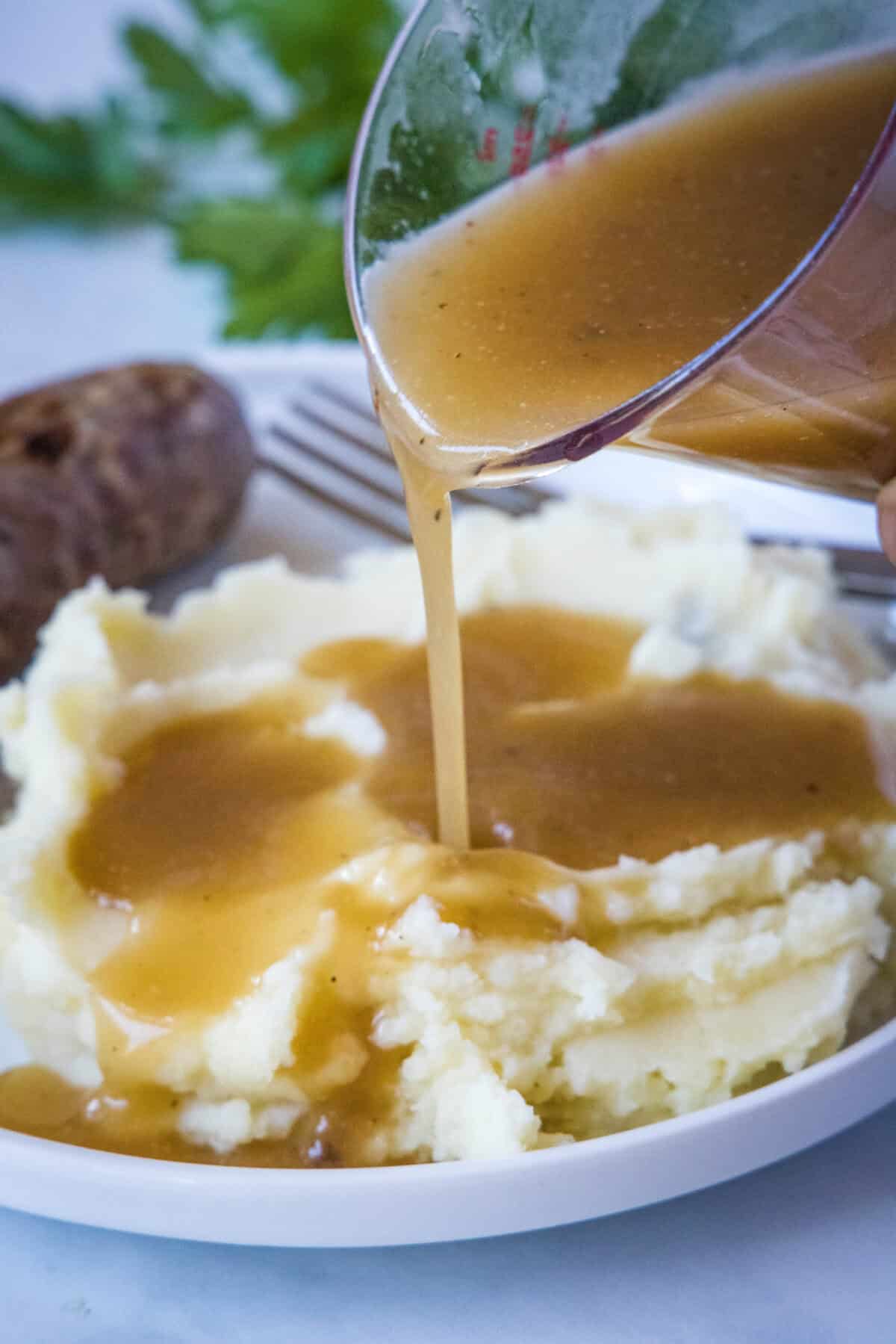 pouring gravy onto potatoes