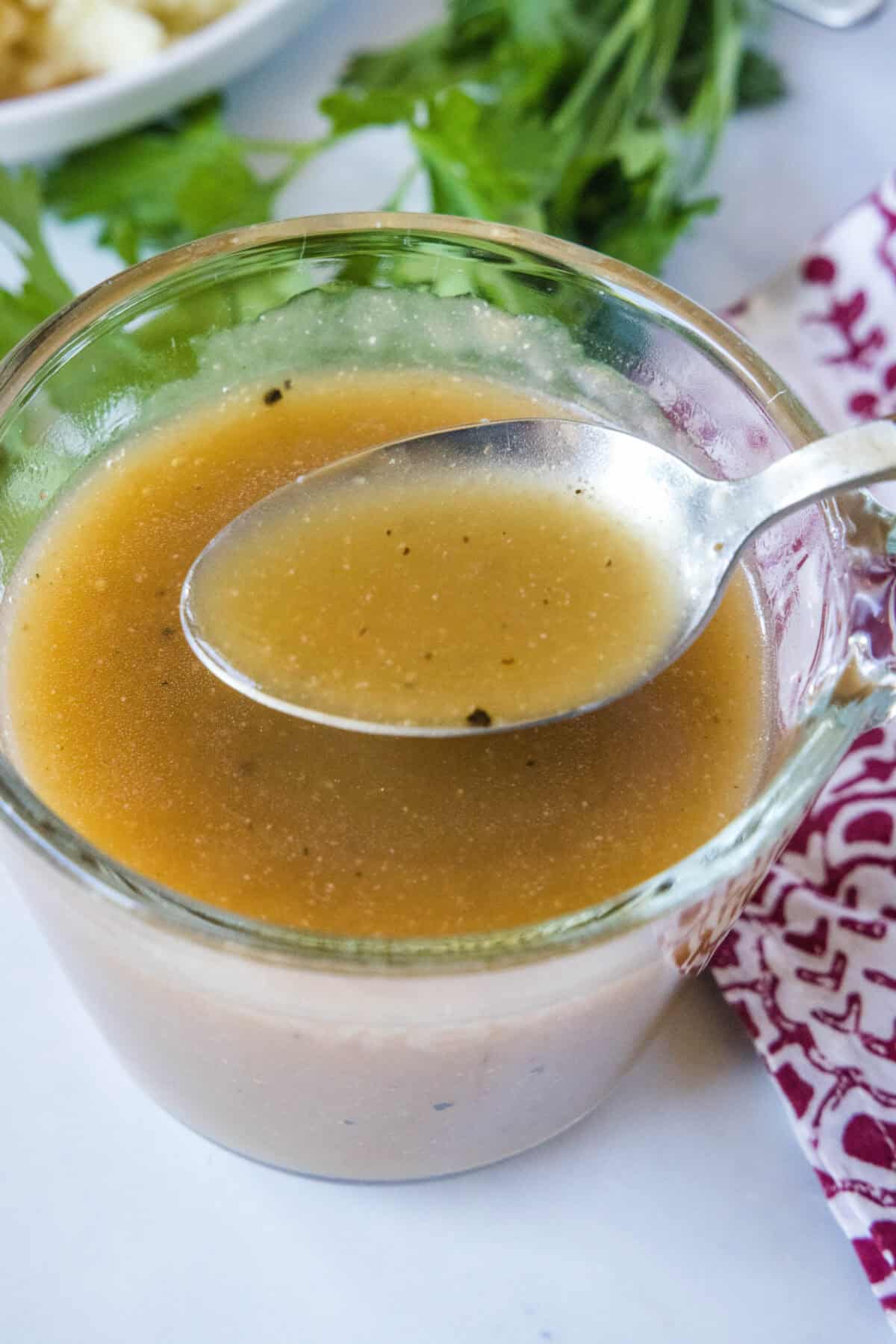 spooning brown gravy out of a up