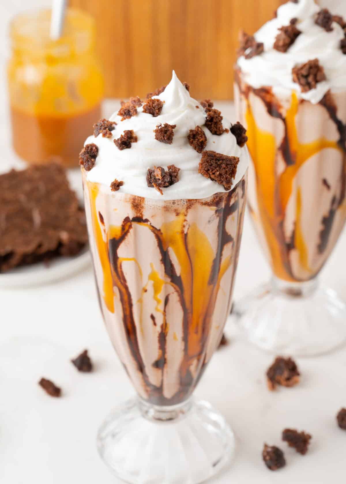 brownie milkshakes in glasses topped with whipped cream and brownies