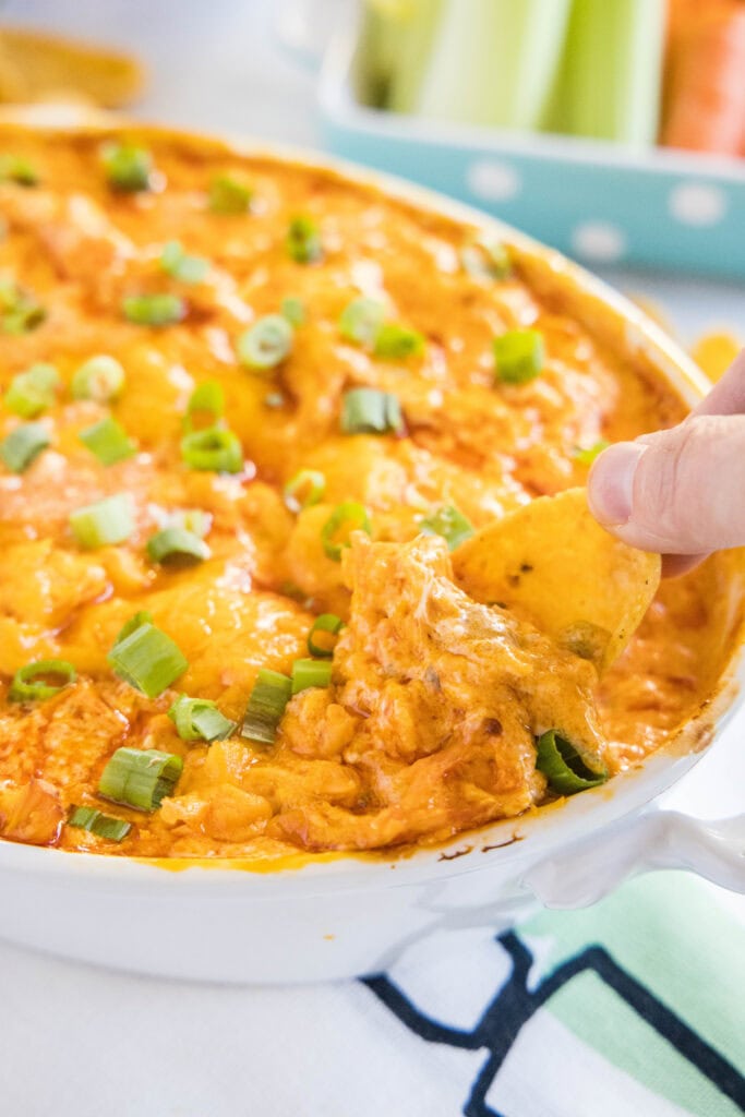 fritos dpped into a dish of buffalo chicken dip