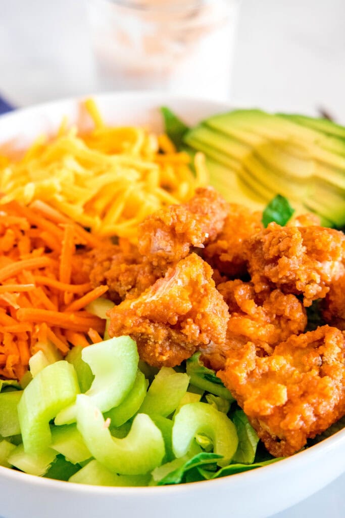 close up crispy buffalo chicken on a salad