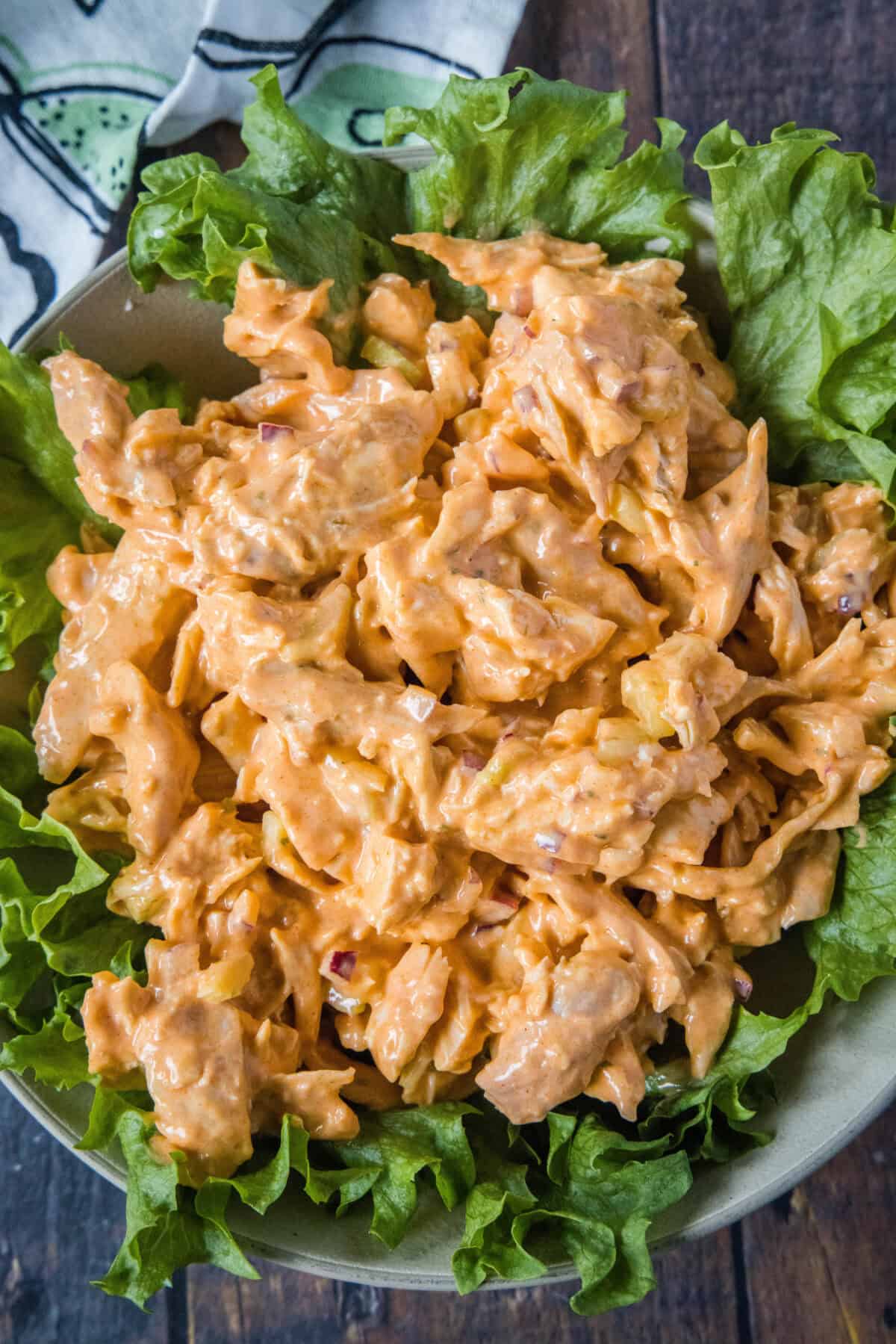 looking down on a plate with buffalo chicken salad over greens