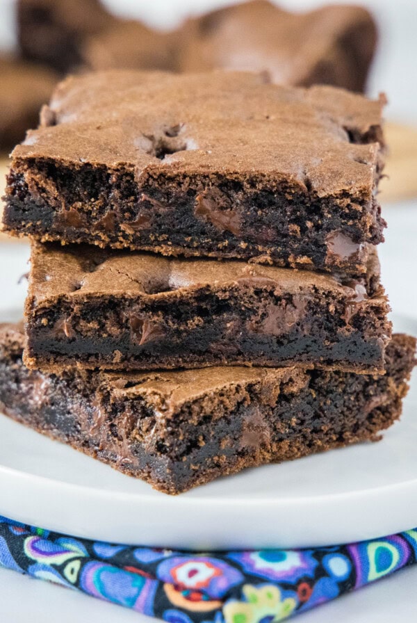 Three squares of brownies stacked on a plate