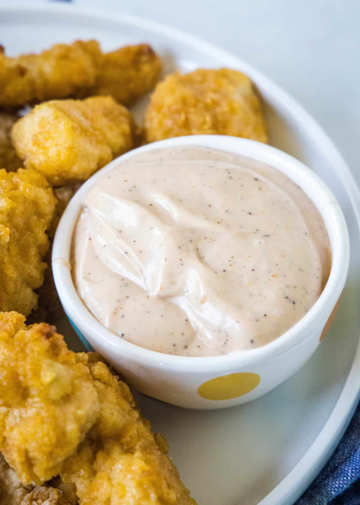 canes sauce in a bowl with chicken around it