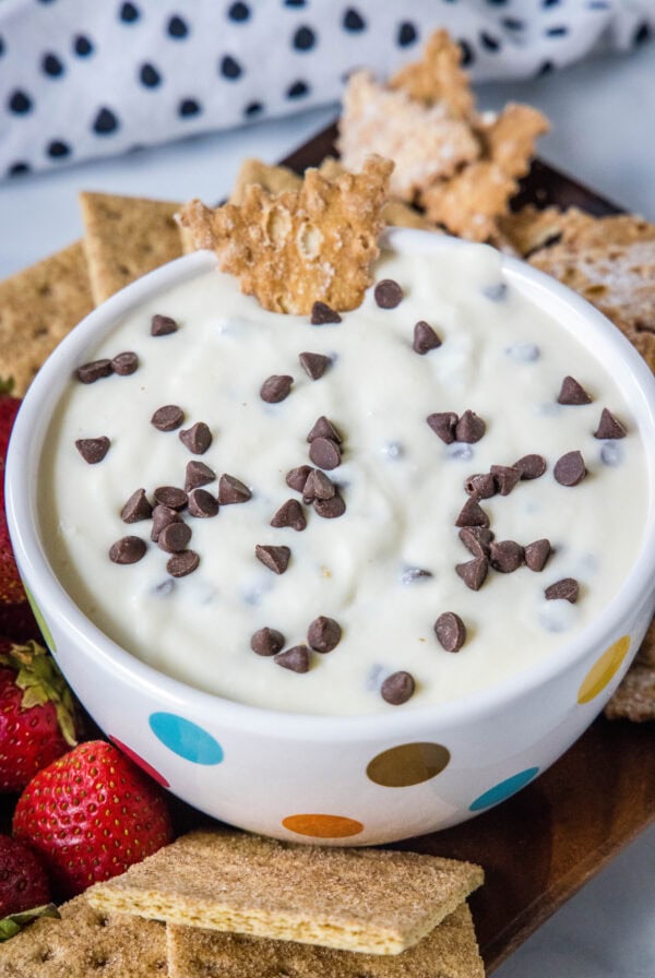 Cannoli dip in a bowl surrounded by a platter of graham crackers.