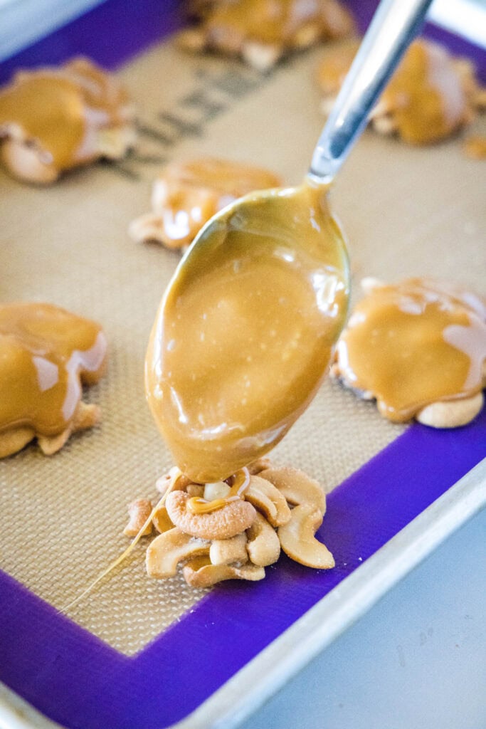 spooning caramel over cashews