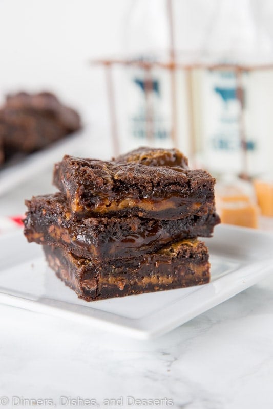 chocolate caramel brownies stacked on a plate