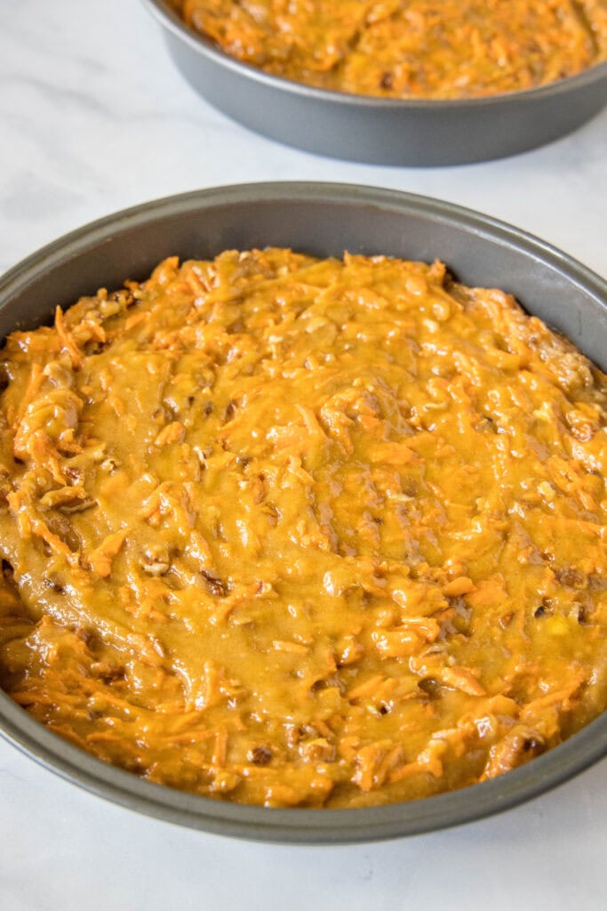 Round pans filled with carrot cake batter.