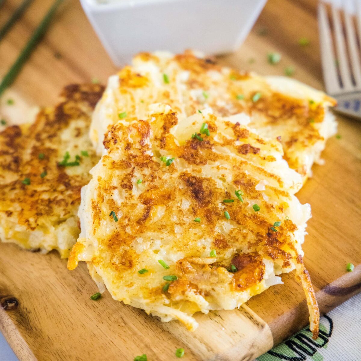 Close up of two cauliflower fritters in a stack, next to a fork