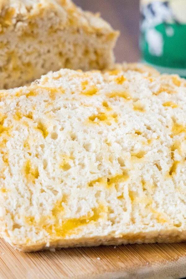Close up of a slice of beer bread leaning against a loaf