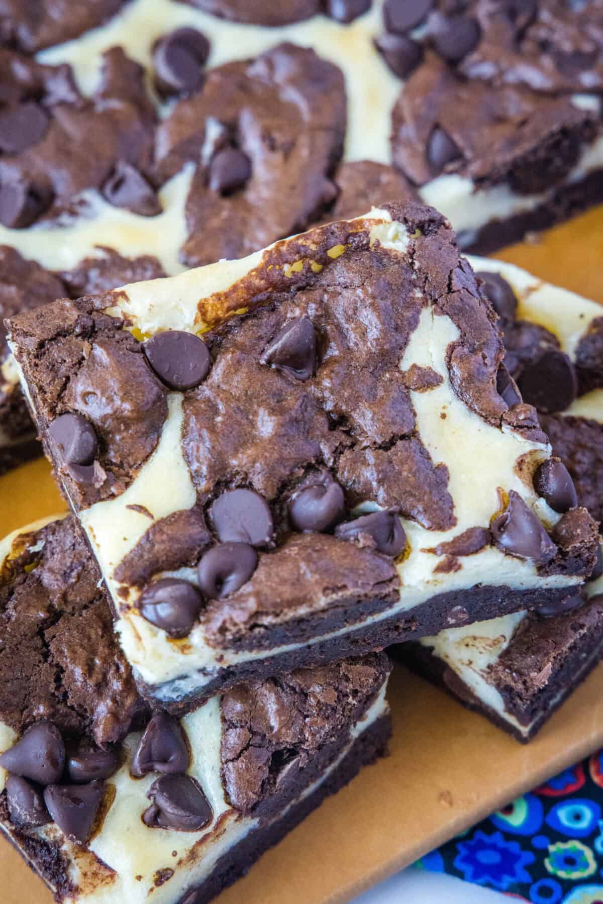 chocolate cheesecake brownies sliced on a cutting board