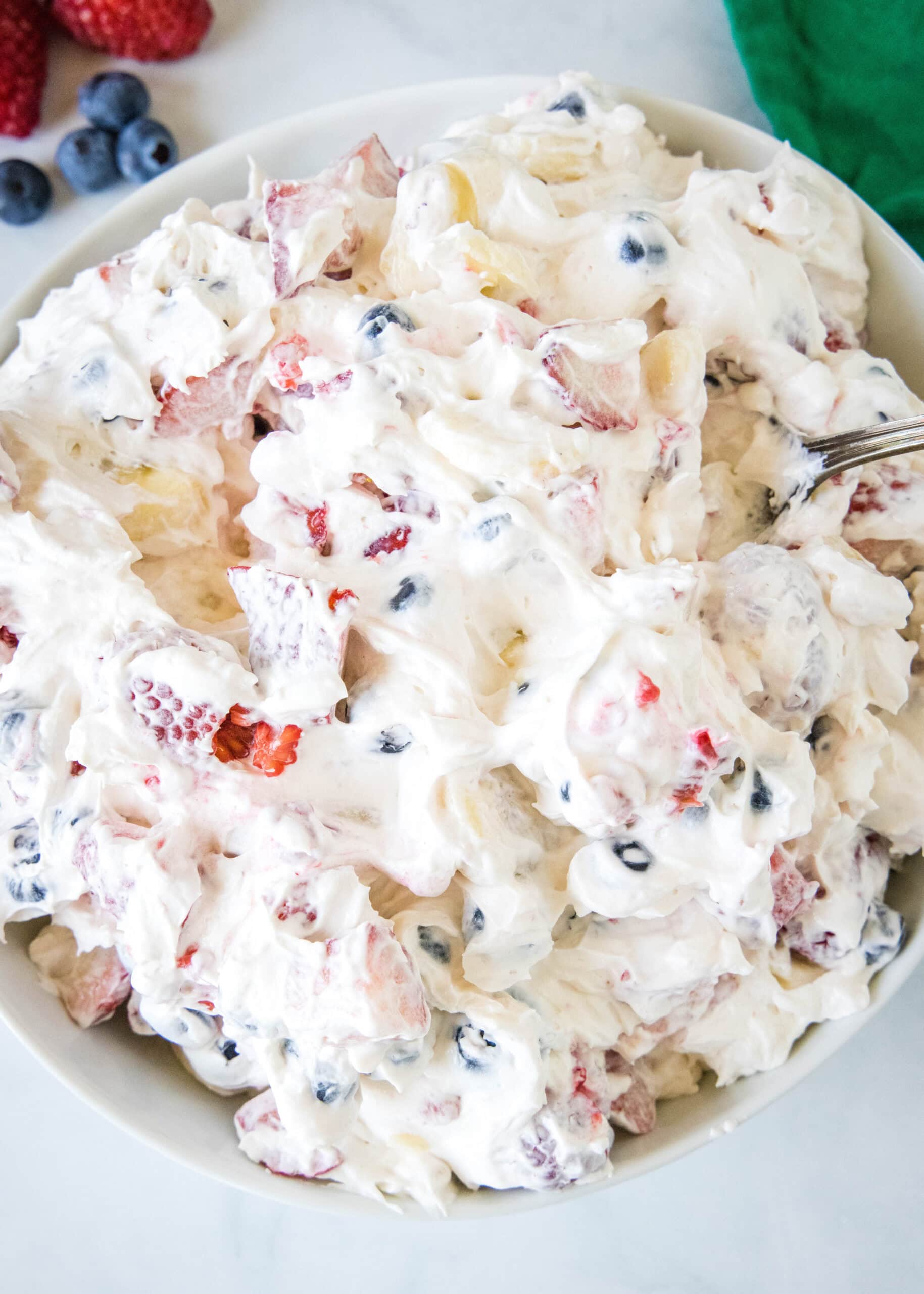 Overhead view of cheesecake fruit salad in a bowl.