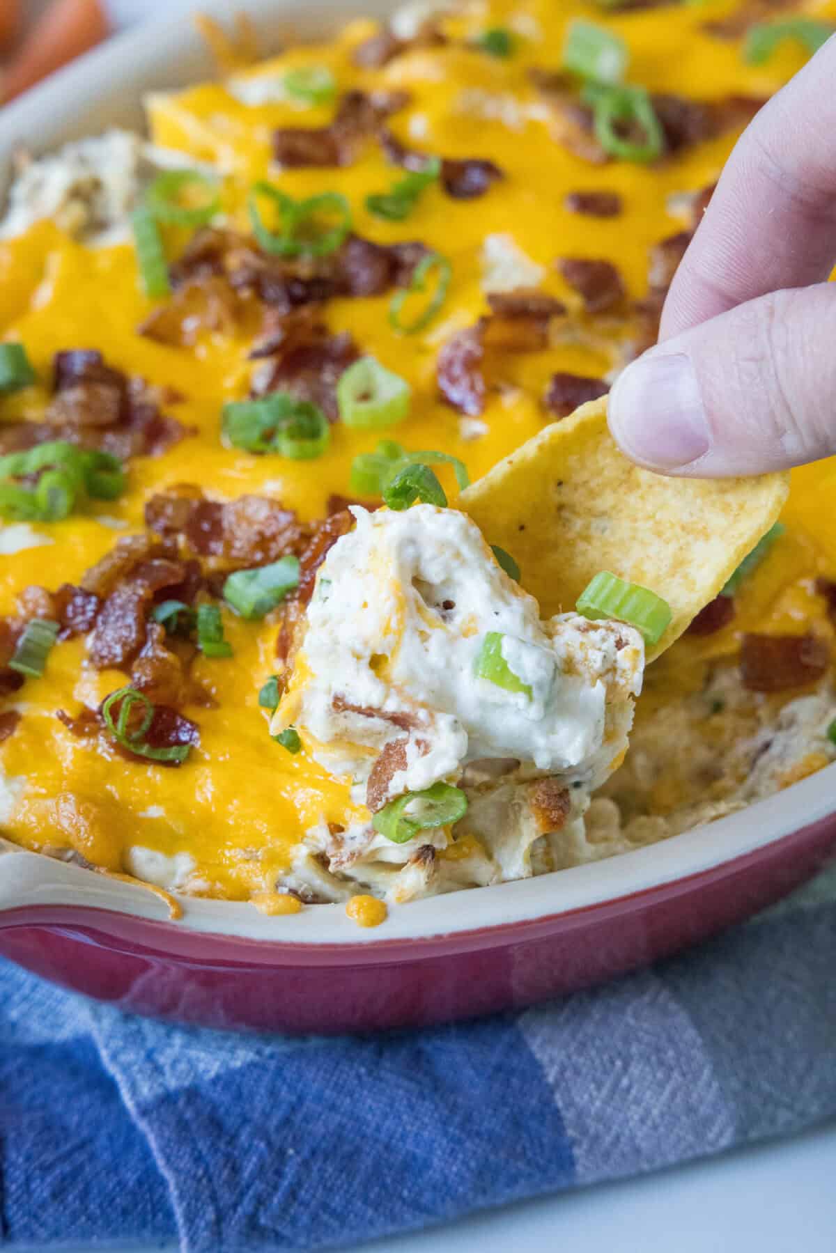 scooping chicken bacon ranch dip out of baking dish