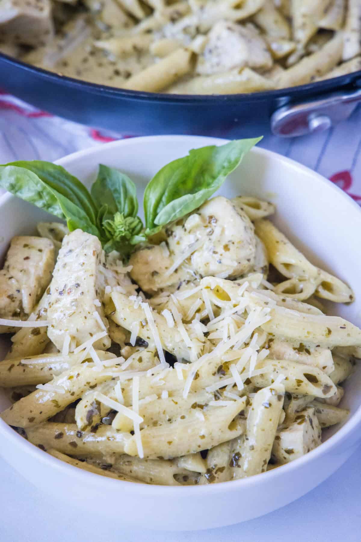 looking down on white bowl with chicken pesto pasta