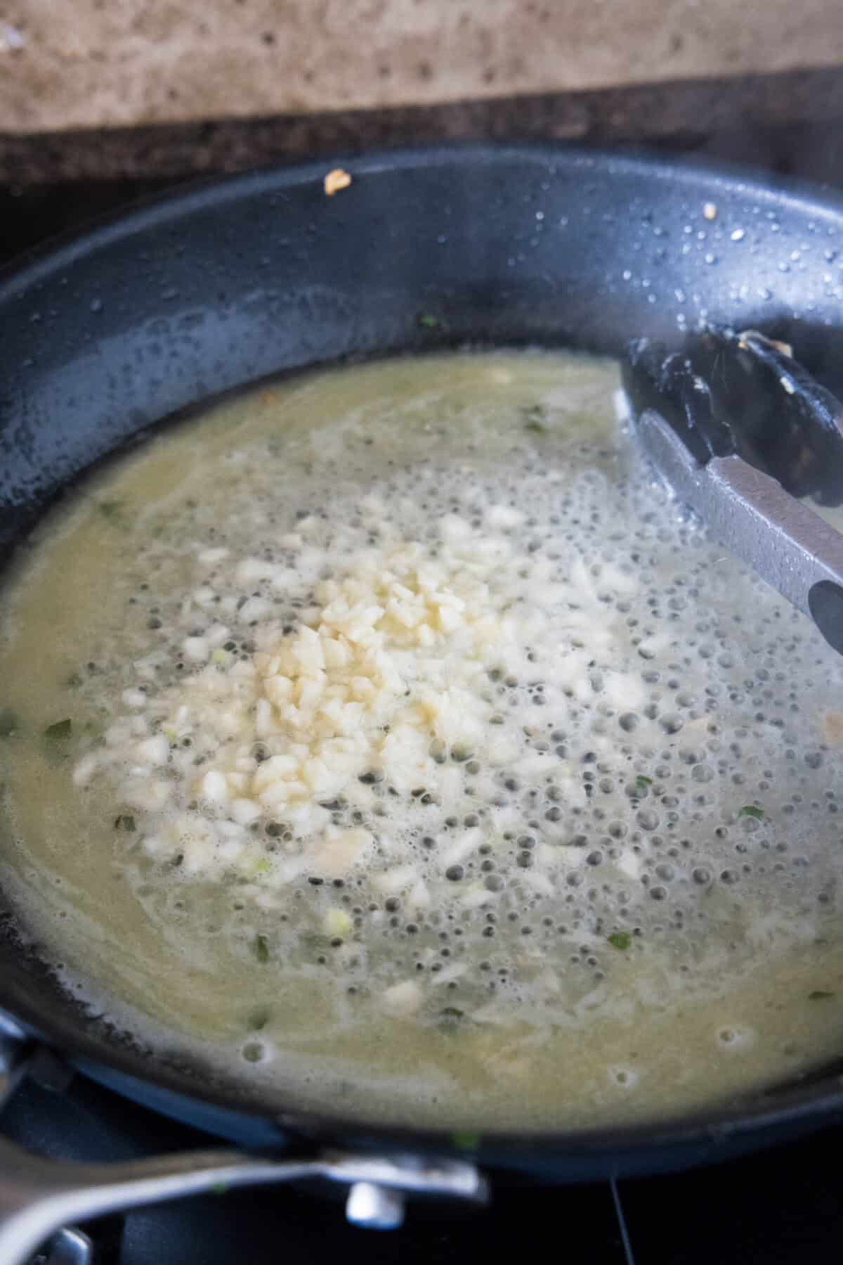 Minced garlic added to butter and olive oil in a skillet.