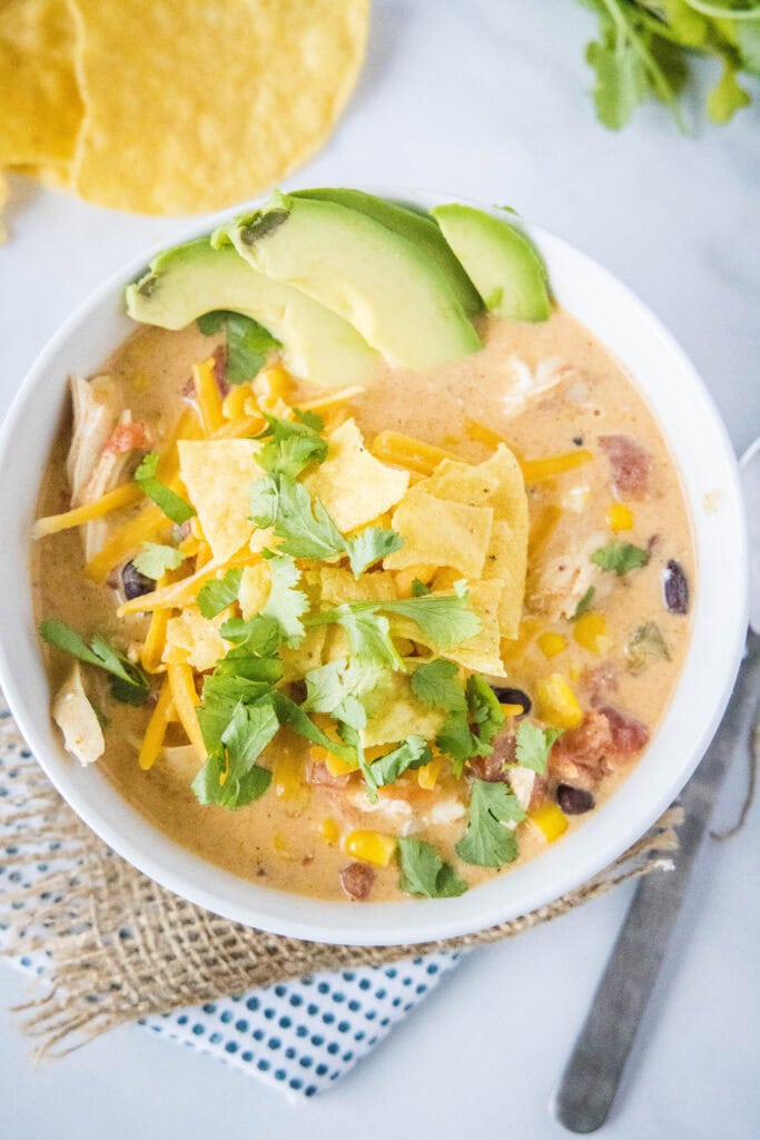 looking down on a bowl of chicken taco soup with cilantro and tortilla chips