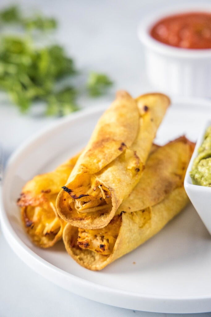 baked chicken taquitos on a white plate