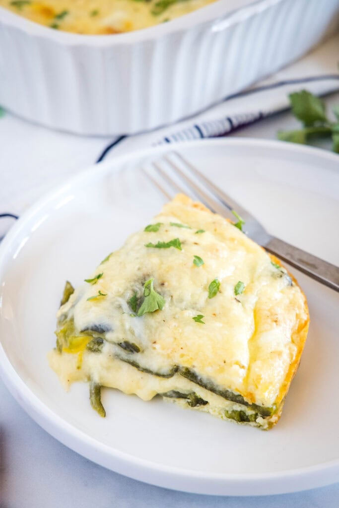 looking down on a white plate with a slice of chili relleno casserole and fork