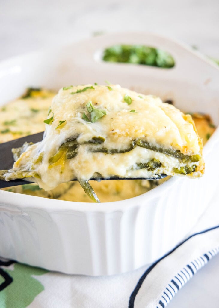 taking a slice of chili relleno casserole out of baking dish