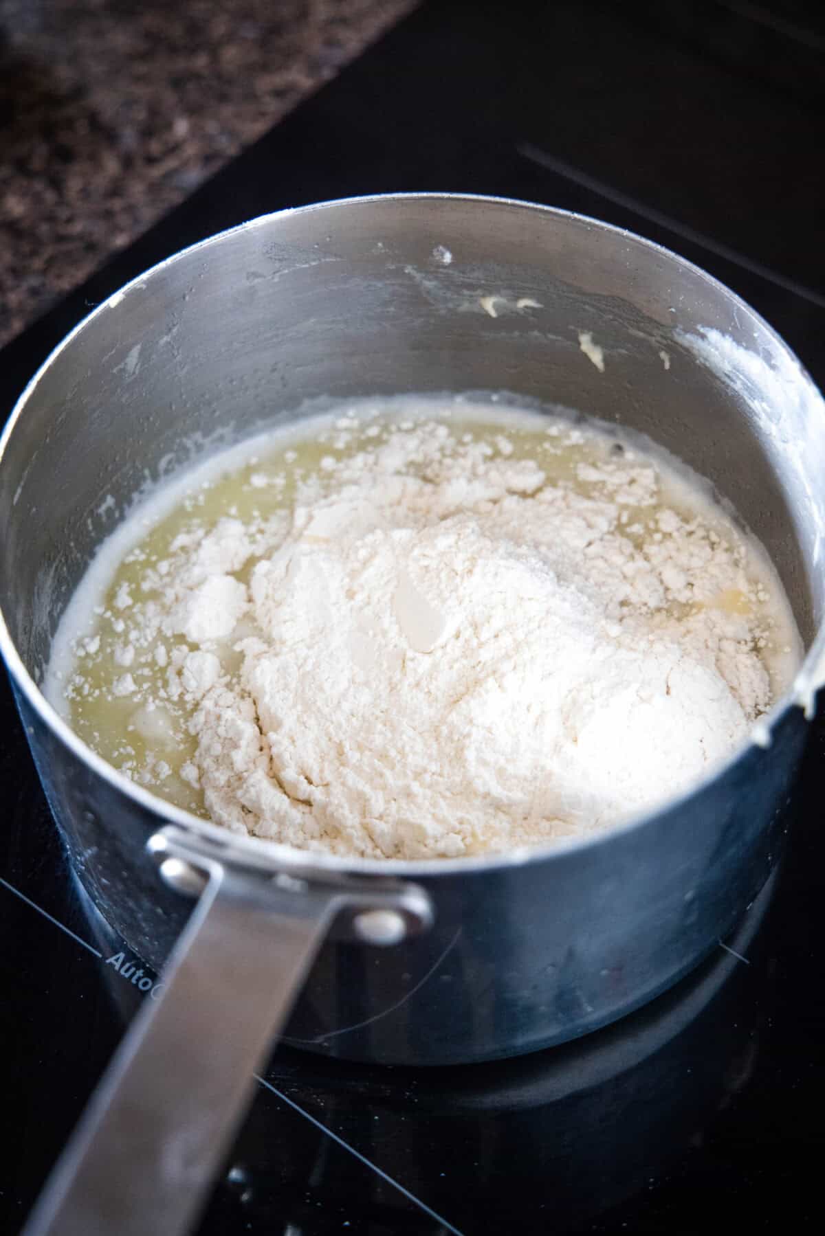 Flour added to melted butter and water in a saucepan.