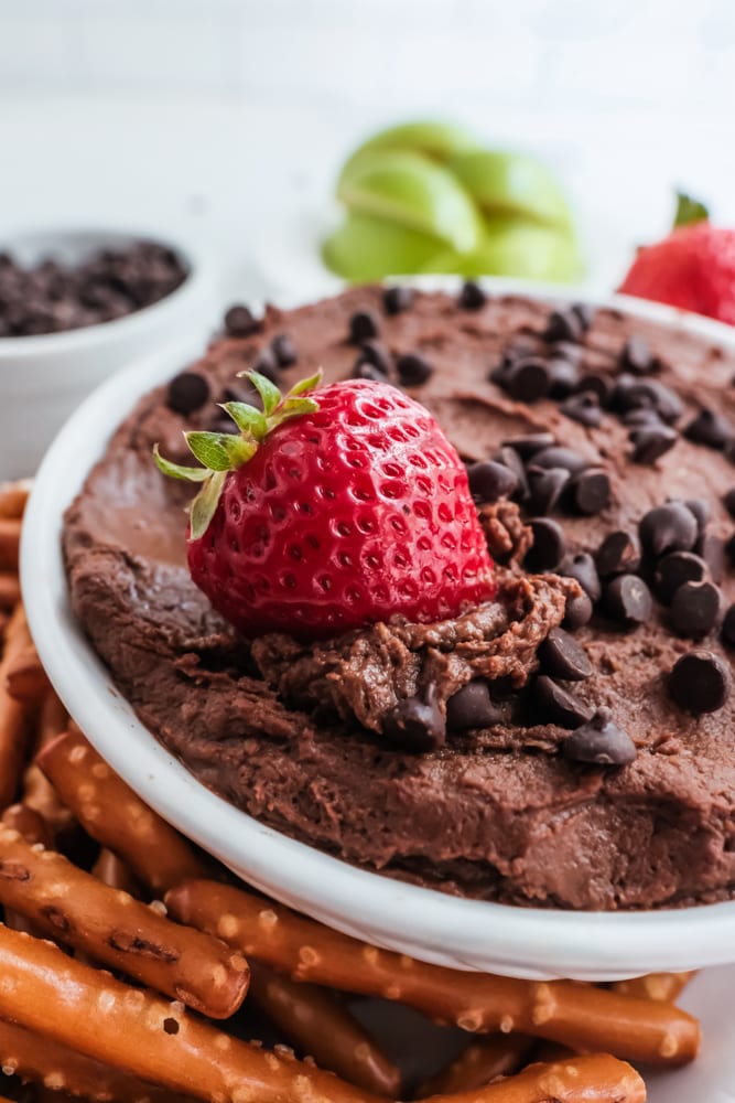 chocolate hummus in white bowl with strawberries