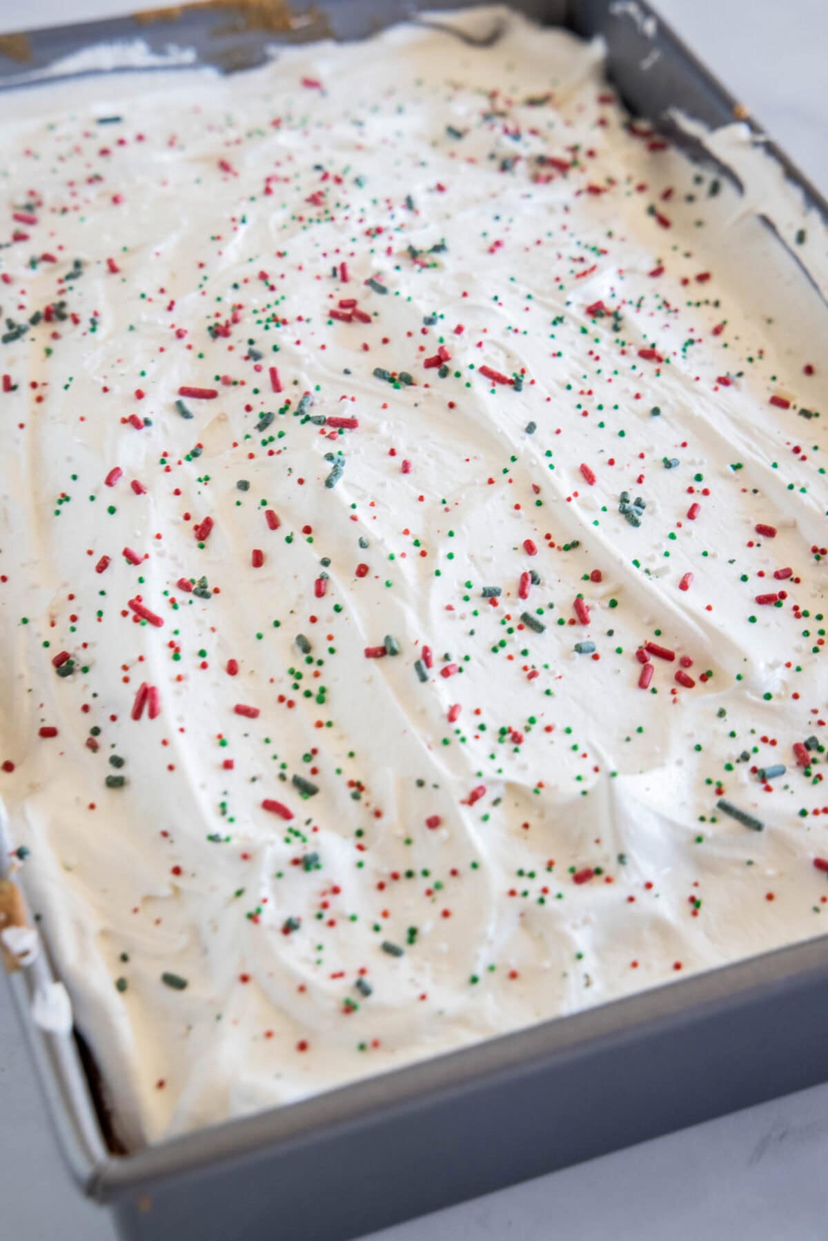 cake in baking pan with christmas sprinkles