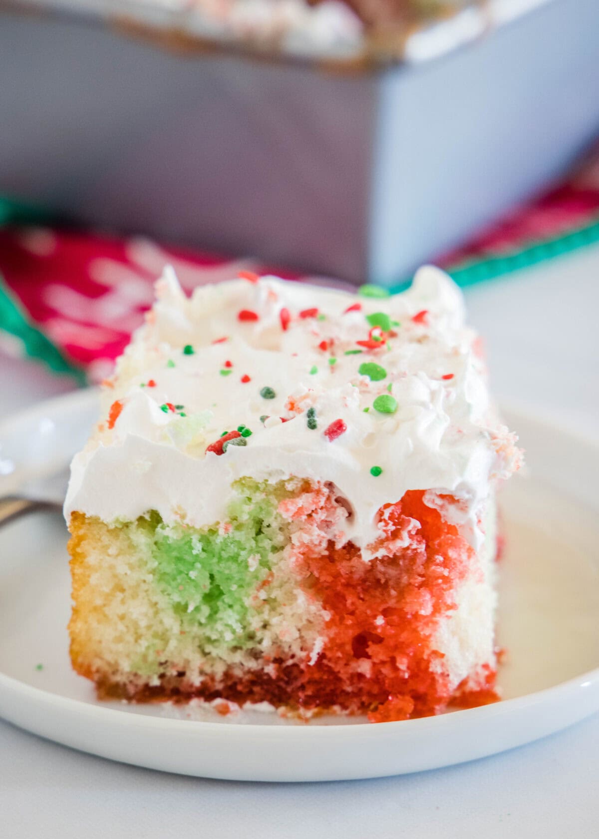 red and green poke cake on a white plate